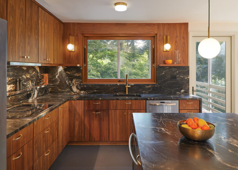 In the renovated kitchen, walnut cabinets are paired with Belvedere granite countertops and backsplash.
