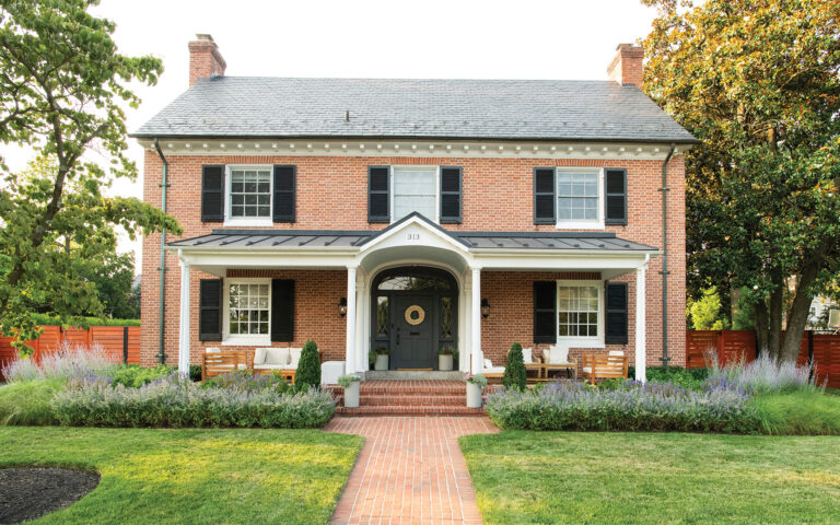 A charming front porch and classically arranged landscape—with symmetrical plantings and an expansive lawn—reflect the historic character of downtown Frederick, Maryland.
