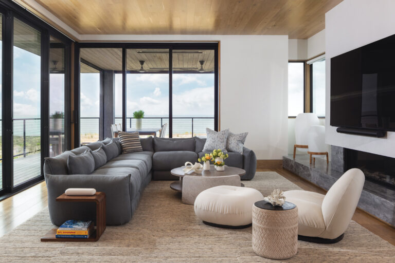 The family room in a waterfront retreat is layered in calming neutrals, with a Verellen coffee table and cozy Pacha lounge chairs.
