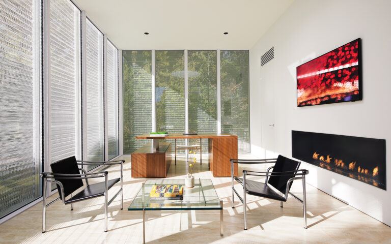 Operable, perforated-metal screens wrap the upper volume of the accessory structure, providing privacy and light.