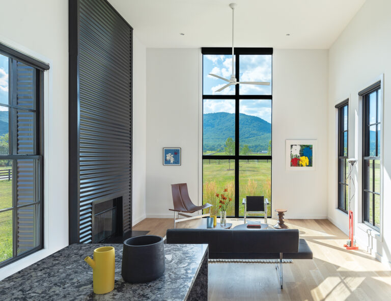 The living pavilion was designed as a single, open space with 14-foot ceilings and a full-height window framing mountain views.