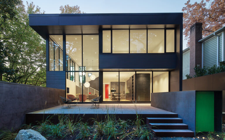 Built on the footprint of a developer tract house in Bethesda, a renovation features a window wall with large sliding doors to the backyard.