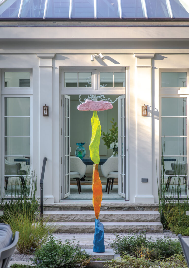 A painted stone-and-steel sculpture by Swiss artist Ugo Rondinone sounds a playful note in a traditional courtyard.