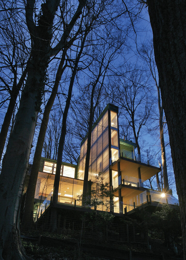 A narrow, rectangular volume clad in glass connects indoor-outdoor spaces.