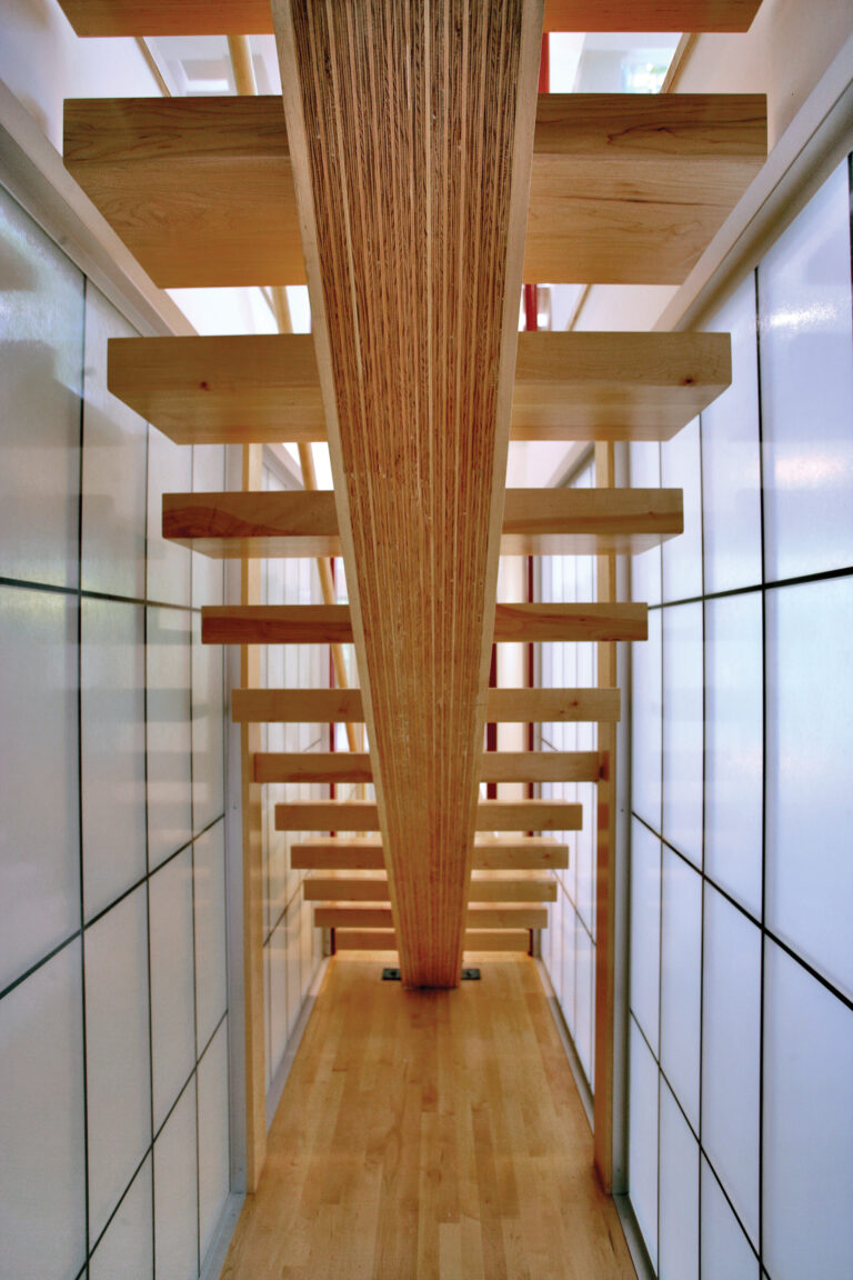 A floating stair extends upward via a narrow passage clad in translucent glass.