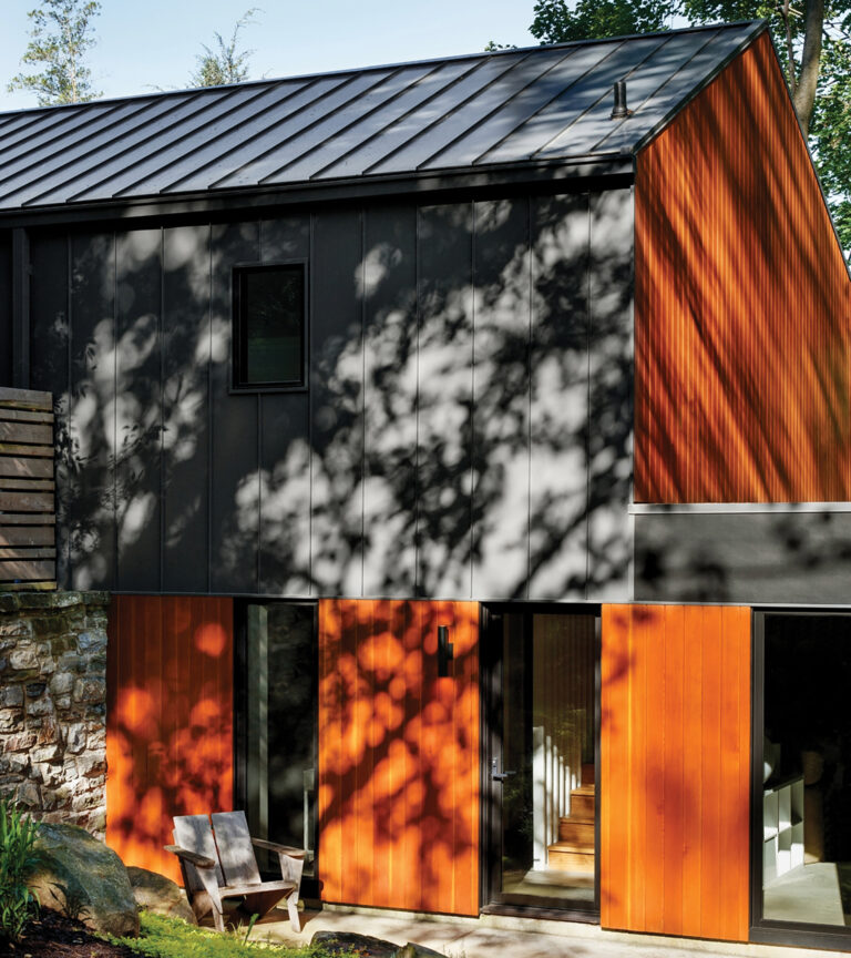 Dark-gray siding and expanses of V-groove Douglas fir enable a building to blend into its surroundings.