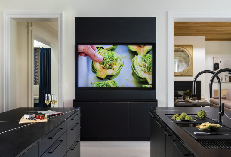 Matte black cabinetry, clear work zones and double islands take a luxe kitchen to the next level. A 75-inch LED screen provides access to a favorite recipe or family video call—all from the prep island.