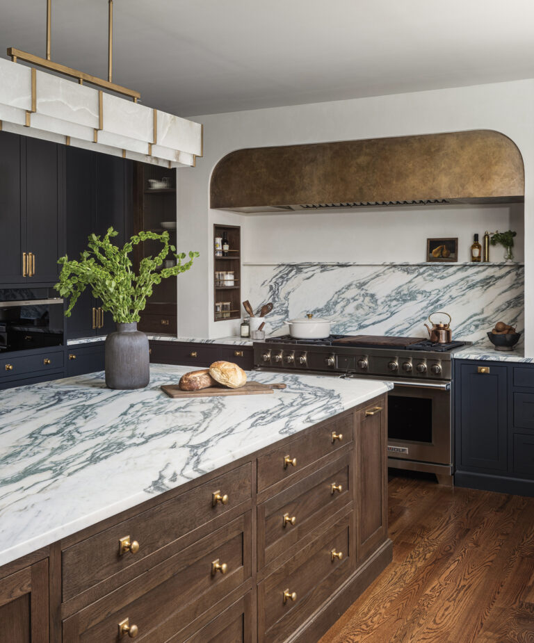 Elizabeth Reich overhauled a dated kitchen in Forest Hill, Maryland, with dynamic marble surfaces, off-black cabinetry and a furniture-style island.