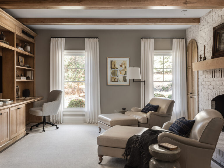 Kristina Kral blended function and comfort in a Baltimore-area family room/home office; a limewashed fireplace, warm wood architectural elements and custom arched doors provide a soft, tonal palette.