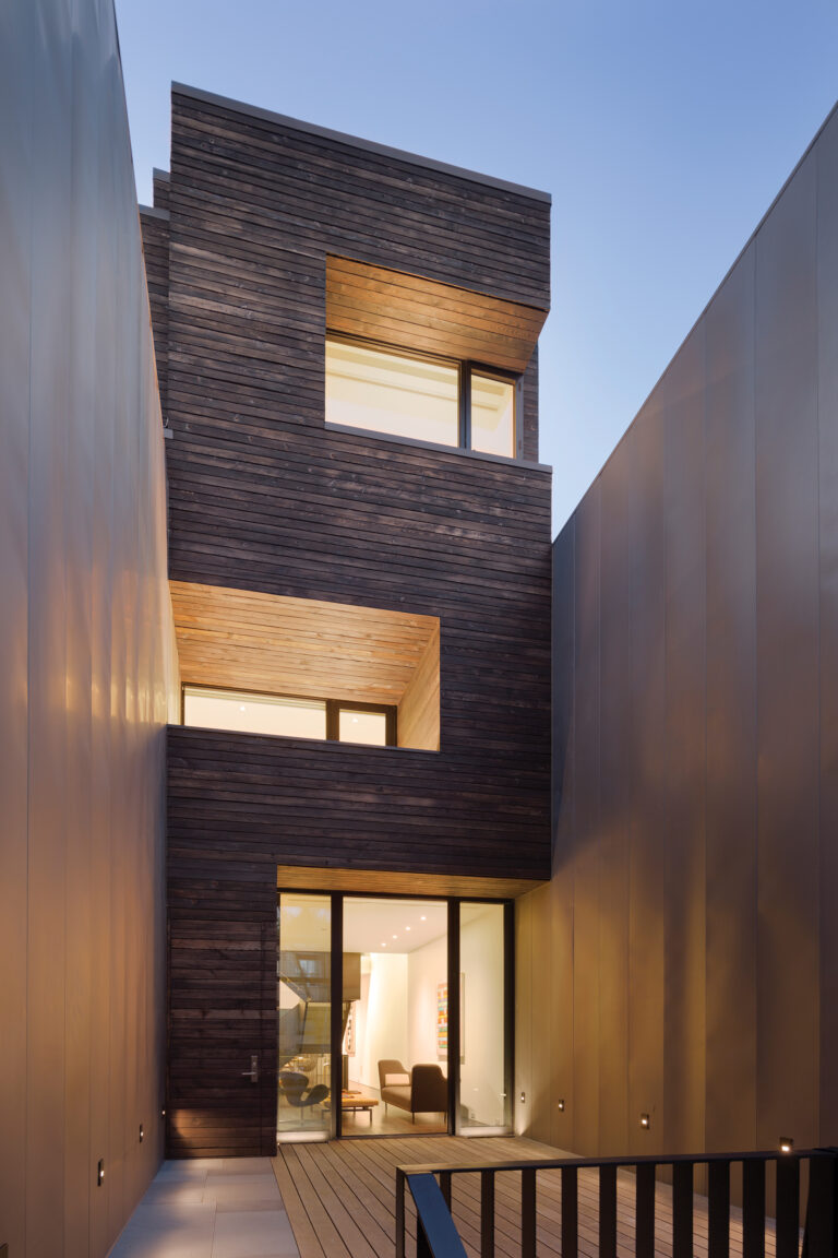 Screened by metal-clad walls, Ontario Residence features burnt-wood siding and a roof deck.