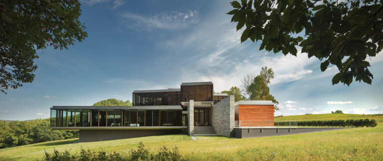 Stone walls orient Wildcat Mountain Residence to its site; balanced above heavy wall elements, a glass-enclosed pavilion is a lens to the landscape.