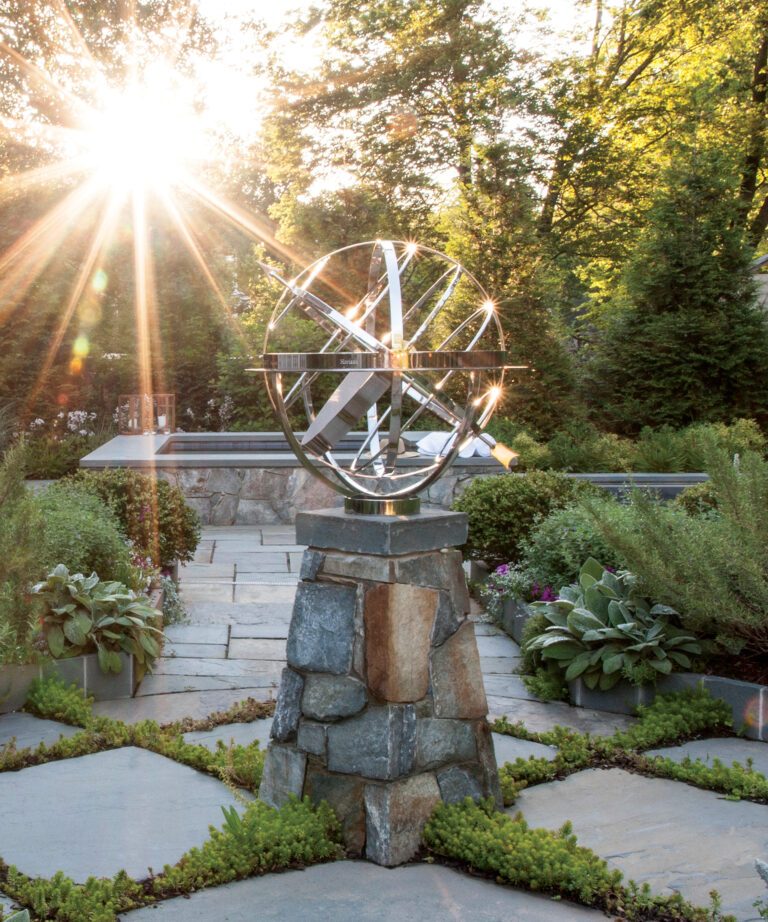 A garden centers on a marine-grade, stainless-steel sculpture shaped like a gyroscope and designed by David Harber.