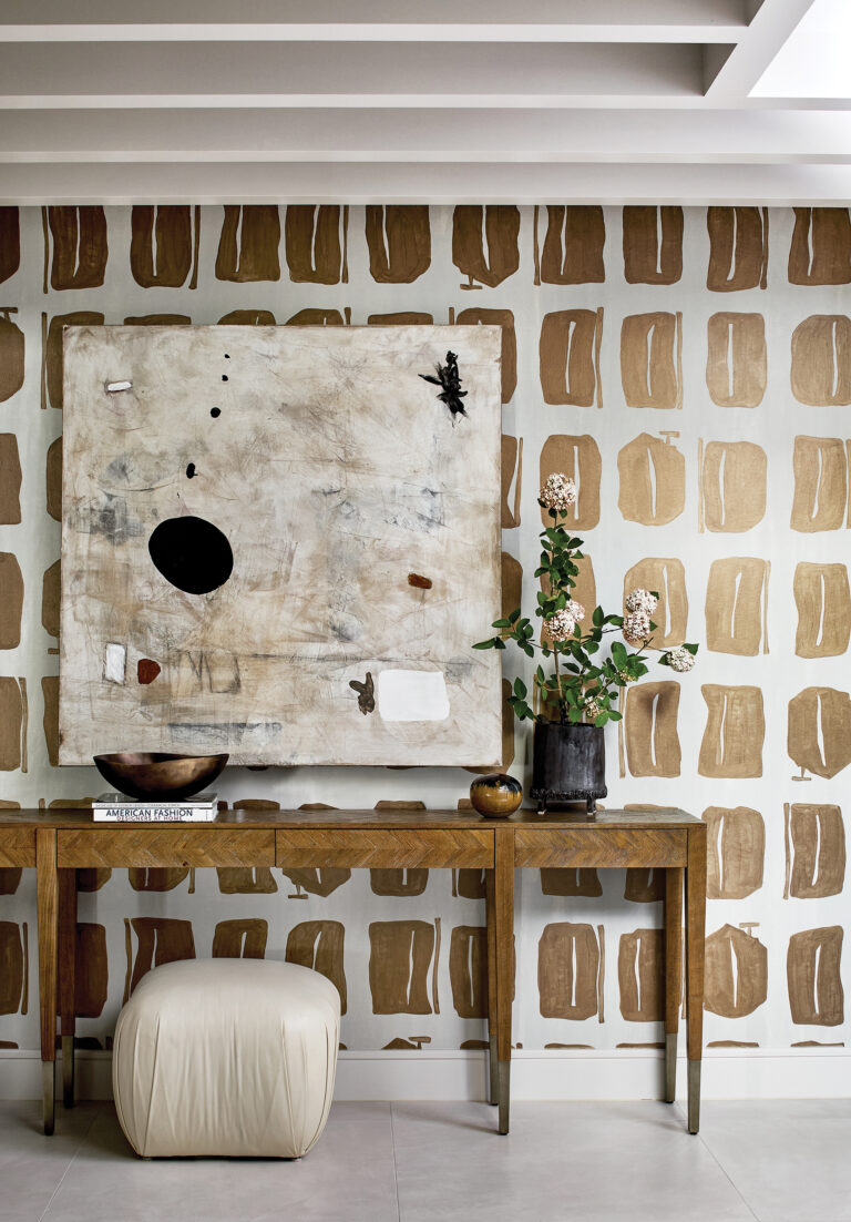 In an entry hall, modern wallpaper is a statement-making backdrop for a curated mix of new and old items.