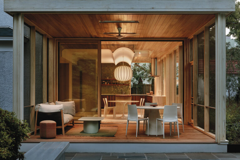 A rear addition features wood-framed windows and a wood-plank ceiling. Sliding doors open to the three-season porch.