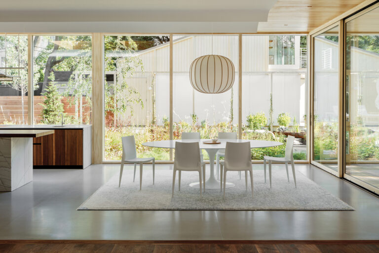 Even in an urban setting, Healey and team work to connect with the landscape. In the dining room, floor-to-ceiling windows overlook a meadow, trellis and complementary new accessory structure.