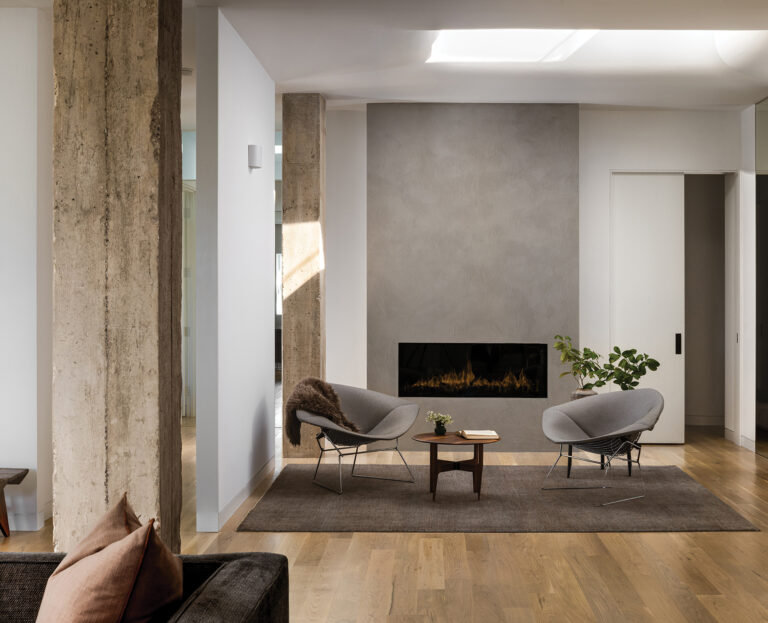 Rough concrete columns were left exposed in a Kalorama penthouse, contrasting with the molded-plaster fireplace surround. An existing skylight was sculpted to bounce light into the space.