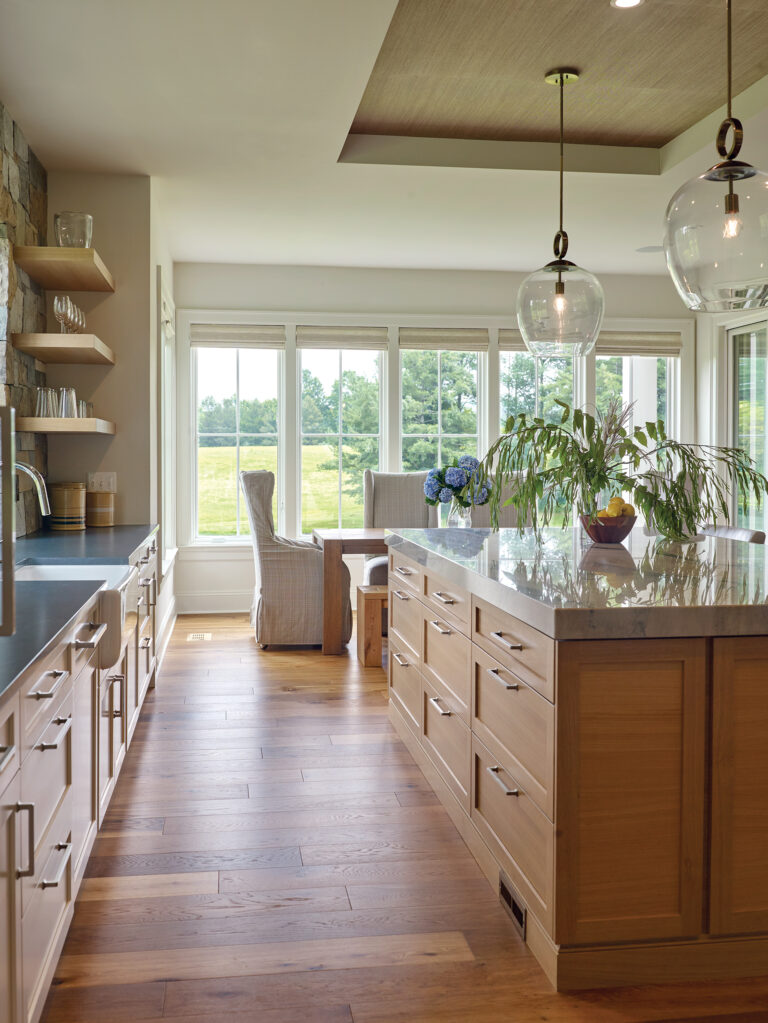 The spacious kitchen encompasses a dining alcove; custom oak cabinetry and a stone backsplash impart a rustic vibe.