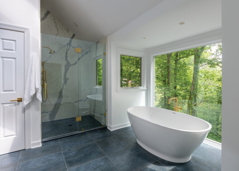 A serene spa features a soaking tub, a marble shower and breathtaking treetop views that blur the line between the indoors and nature.