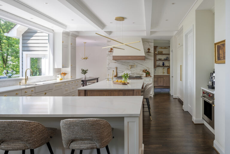 A chic, white kitchen enjoys modern detailing and an expansive picture window. PHOTO: John Cole
