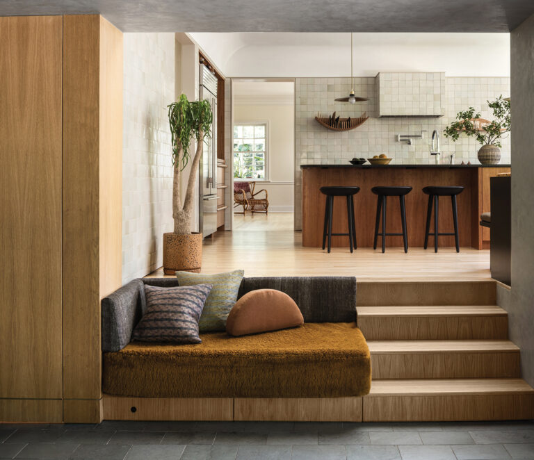 A garage wall was removed to create a sunken family room in a Forest Hills abode; a stair and integrated bench connect to the new kitchen.