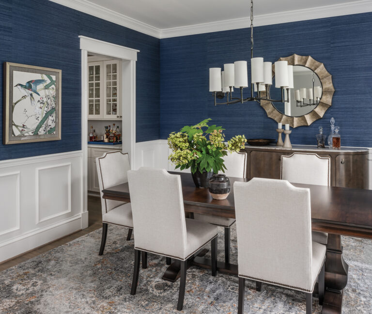 In a Vienna dining room, blue grasscloth wall covering by Pacific Designs embraces formality with an inviting, personal approach.