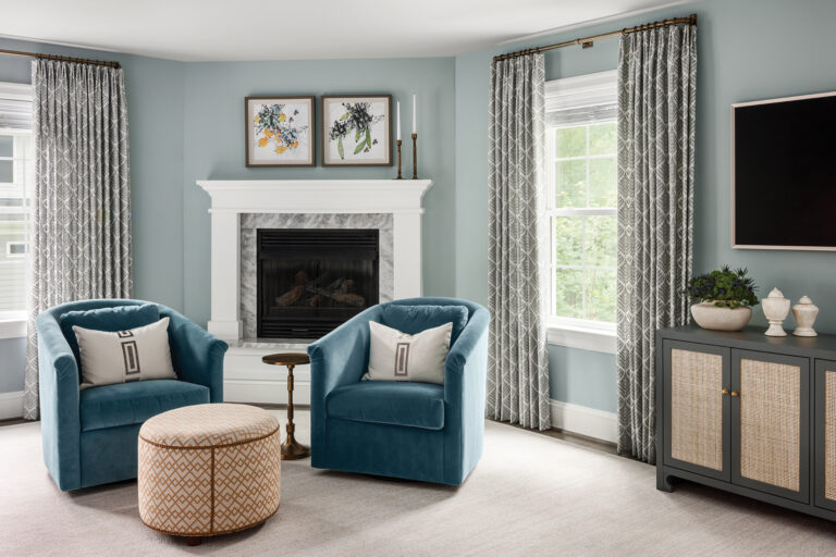 Teal velvet chairs from Rowe Furniture swivel to face the fireplace, windows or TV in a primary bedroom sitting area.