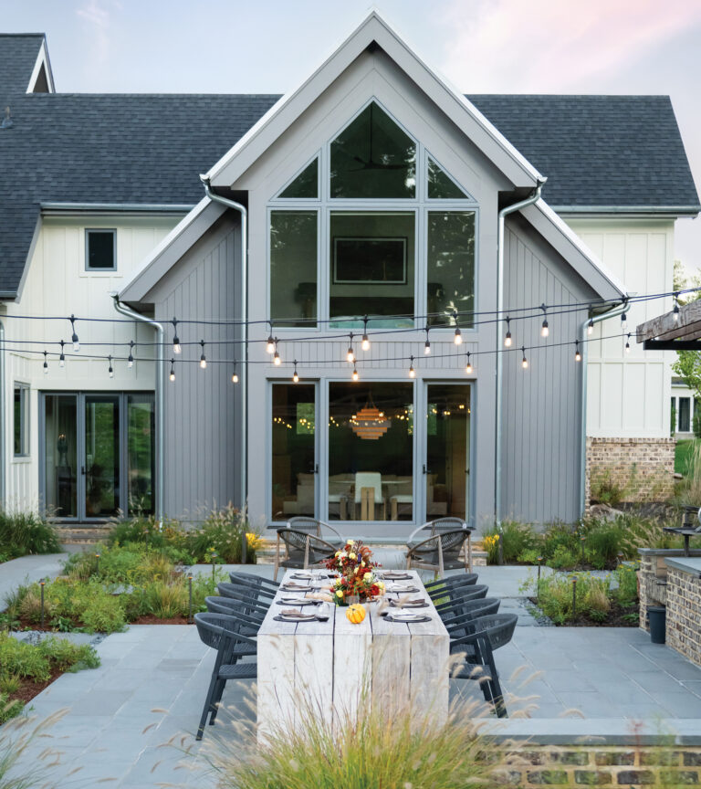 A custom dining table anchors the bluestone dining terrace, bordered on one side by a built-in grill.