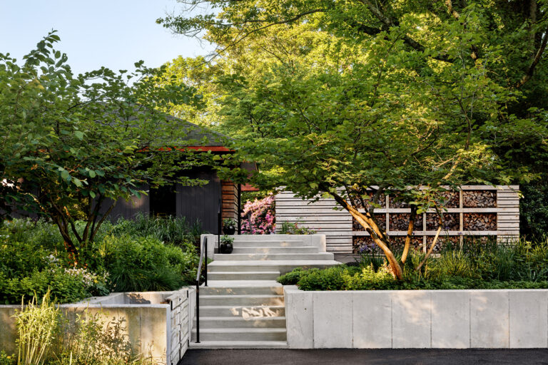 Terraced walls tame the site's steep grades, creating a layered sequence of entry gardens where native plantings, handcrafted details, and carefully framed views connect the home to the surrounding landscape.