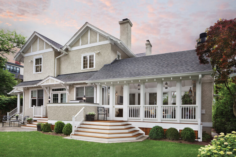 The design of a spacious porch on a Chevy Chase DC abode expresses the architectural roots of the Victorian-era structure; twin roof peaks are a seamless addition to the existing house. 
