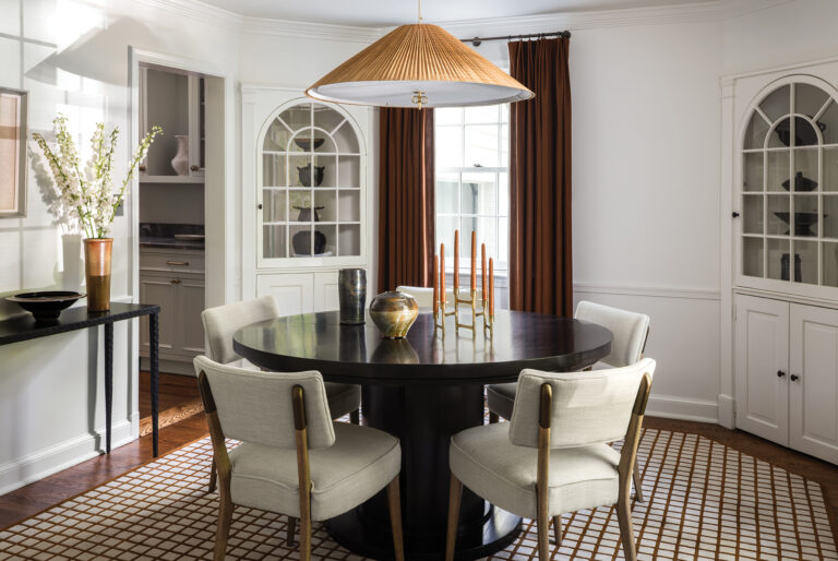 In a DC dining room, a custom, ebonized round table picks up the curves of the built-in cabinets; a woven pendant is a casual touch. 