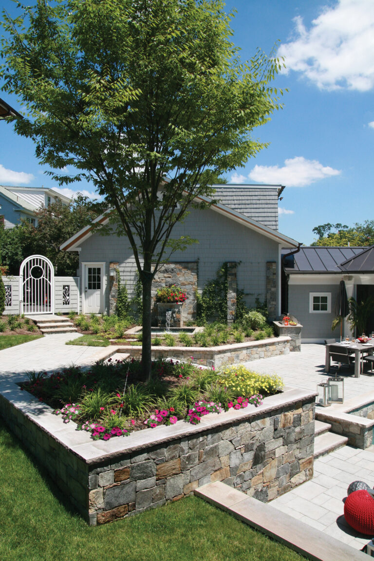 An outdoor living space in Chevy Chase boasts stone terraces, multiple water features and a pool.