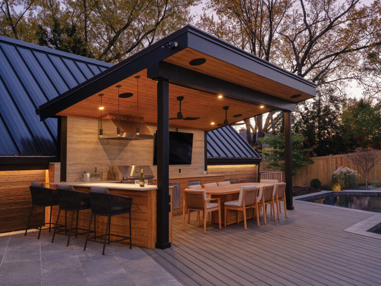 An eye-catching pavilion offers al fresco dining beside a full kitchen and bar. Dekton countertops and backsplash and Somerset appliances complete the look.