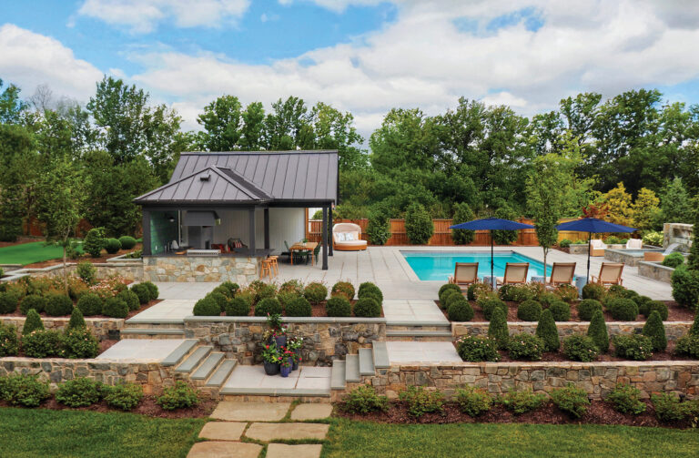 A resort-style poolscape includes a spa with fire feature and waterfall and meticulously landscaped terraces.